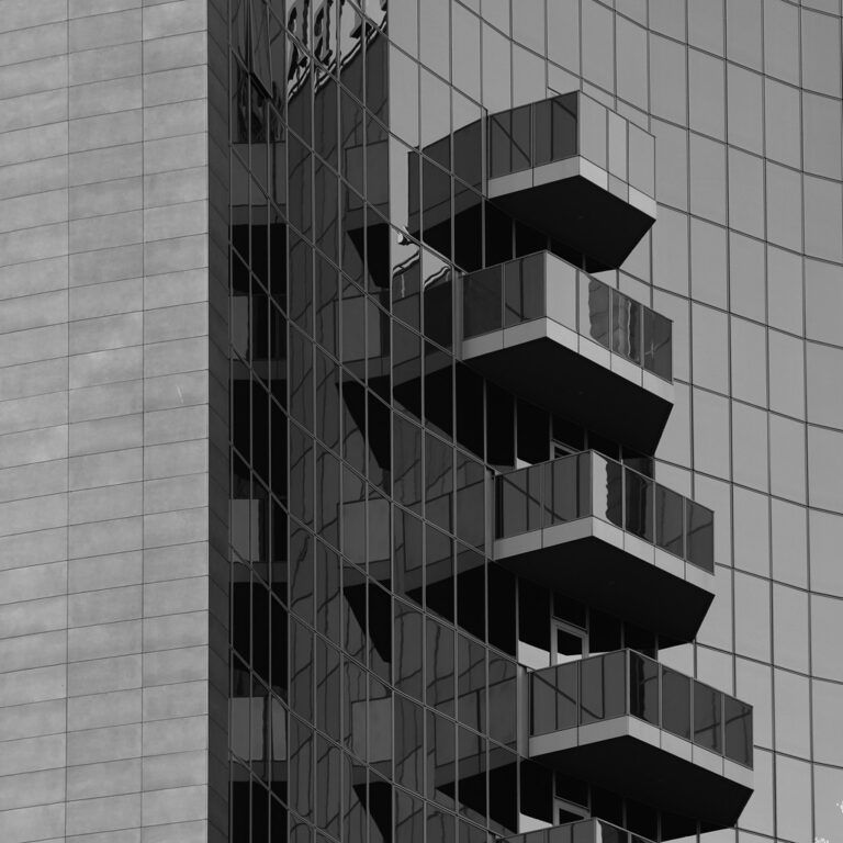 Facade and balconies of a modern building with glass panels and